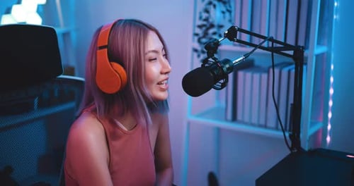 Woman Talks into Microphone Wearing Headphones