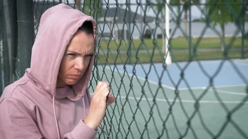 Woman Looking Sad By Chain Link Fence