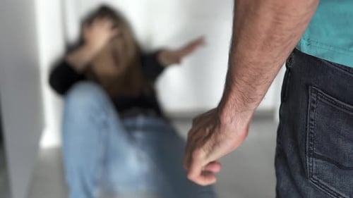 Man Clenching Fist with Woman in Background