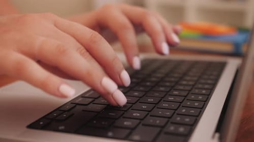 Hands Typing on Laptop Keyboard at Workplace