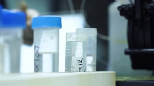 Lab Technician Placing Sample Vial in Medical Lab