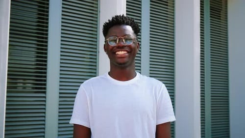 Smiling Man Wearing Glasses Outdoors in an Urban Setting