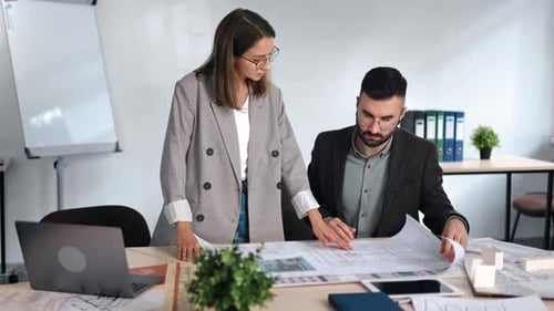 Architects Reviewing Blueprint in Bright Office