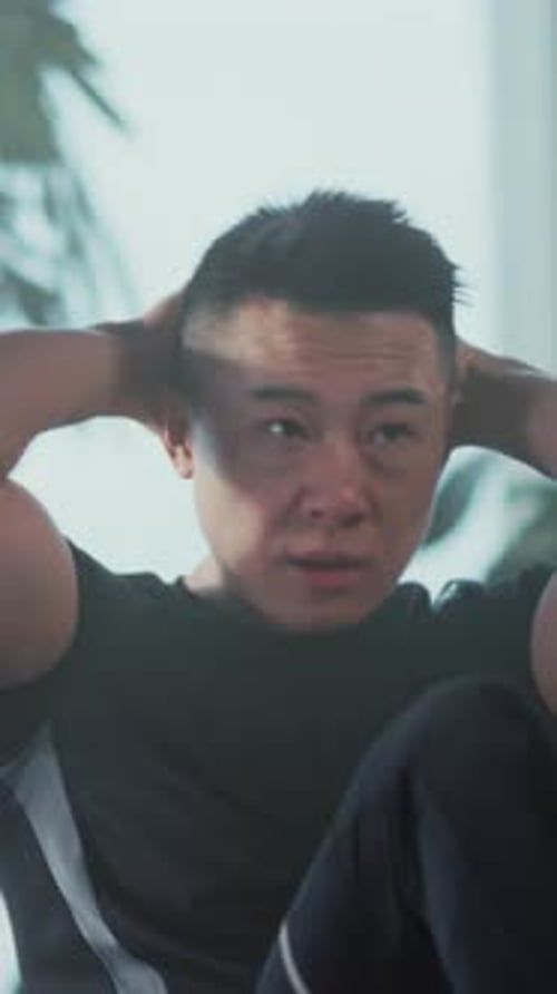 Man Doing Sit-ups on a Couch at Home