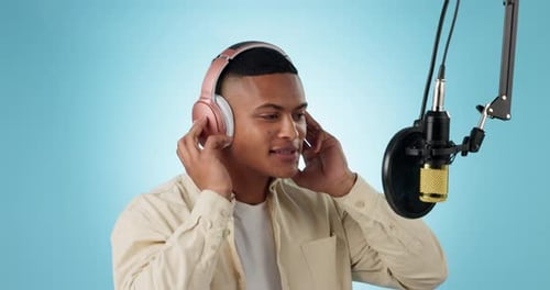 Rapper, musician and man recording music or audio isolated in a studio blue background to sing