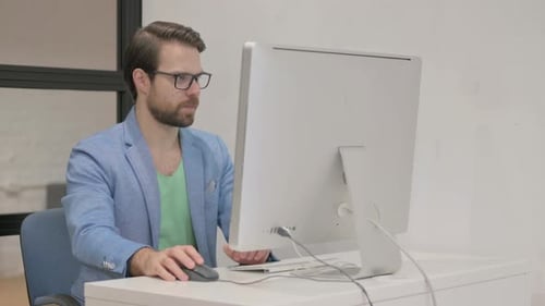 Junger Mann schockiert über den Verlust seines Desktop-Computers im Büro