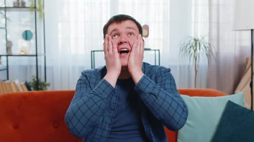 Man Expressing Shock and Delight Indoors