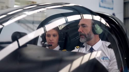Experienced male flight instructor teaching female student pilot