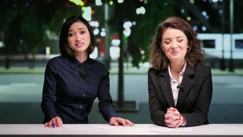 Two Women Broadcasting News in an Urban Studio