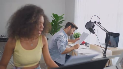 Diverse young stylish audio producer working in the music record studio.