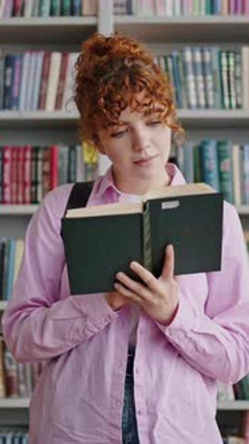 Young Woman Reading a Book in the Library