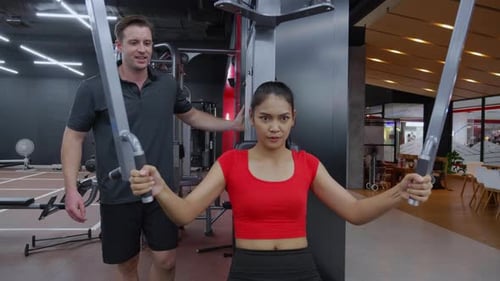 Woman Works Out in Gym With Trainer