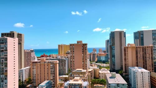 High-rise hotel and blocks of flats in the Waikiki resort. Drone footage at the tops of the building