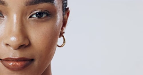 Space, half or face of woman in studio with makeup, glow or earring isolated on white background