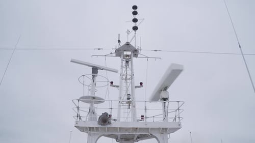 Radar antennas rotating on top of the ship. Radar mast.