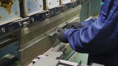Arbeiter biegt Details mit Werkzeugmaschine in Nahaufnahme der Werkstatt