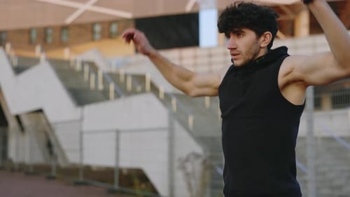Young Caucasian Male Athlete Warming Up Outside in the Street Gym Before the Training or Marathon