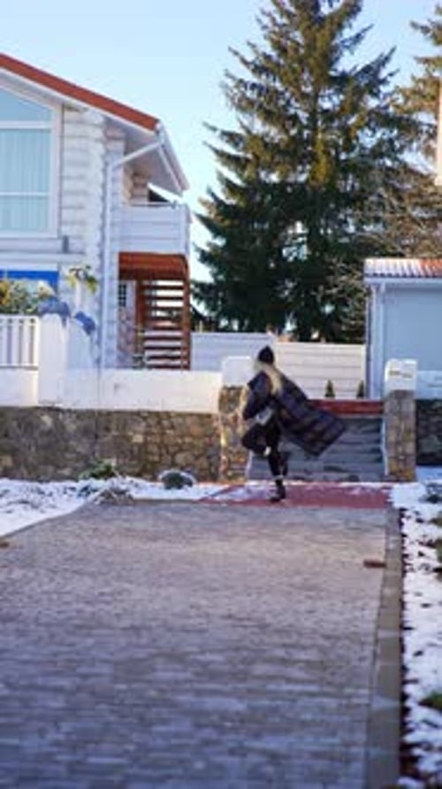 Woman Walks and Jumps Near Suburban Home in Winter
