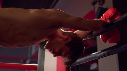 Boxer Resting on Ropes After Workout