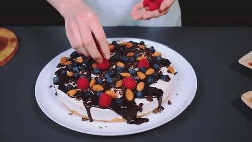 Frosted Cake Being Decorated With Fresh Fruit
