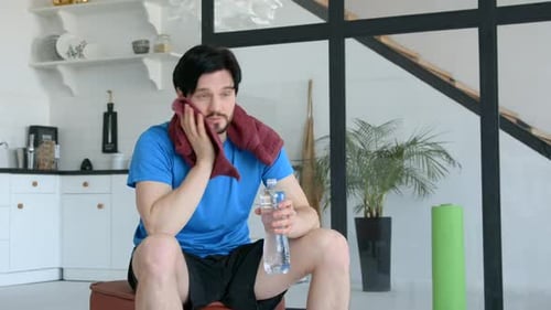 Man Drinks Water After Exercise Wipes Sweat with Towel