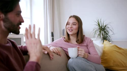 Young Couple Relaxing and Talking on Sofa