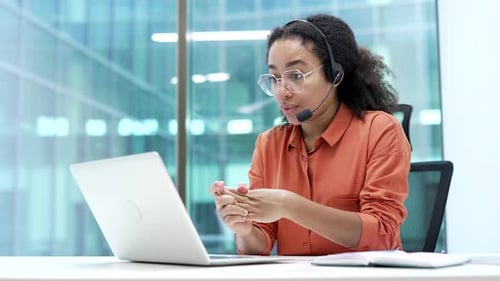 Woman with Headset Talking at Computer in Office