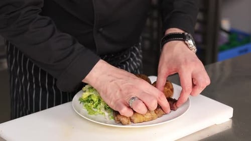 Chef Plating a Steak with Salad and Potatoes