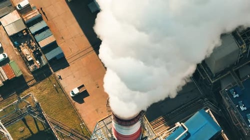 Coal power plant emits large clouds of smoke over industrial area
