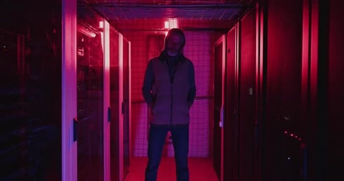 Man Stands in a Futuristic Server Room