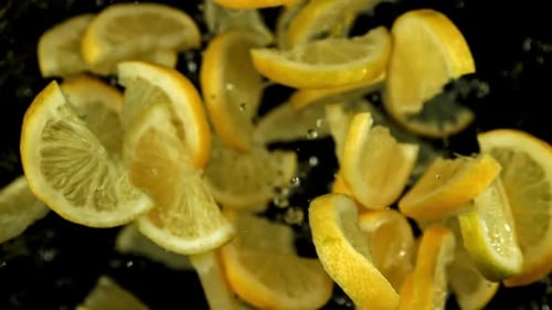 Lemon Slices Flying on a Black Background Filmed on a Highspeed Camera at 1000 Fps
