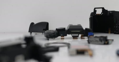 Closeup of disassembled camera body and broken camera parts on the desk in workshop. Broken camera f