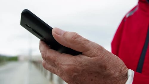 Senior Adult Using Cell Phone Outdoors Close Up