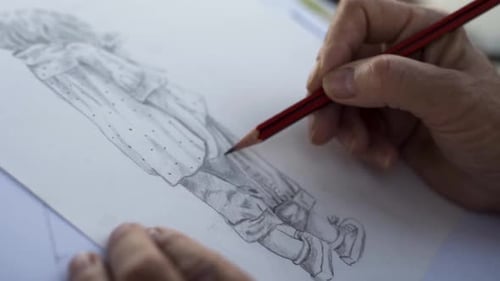Close up shot of person drawing with pencil on paper