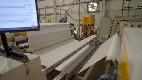 Production for plastic bags - rolling of white plastic roll by