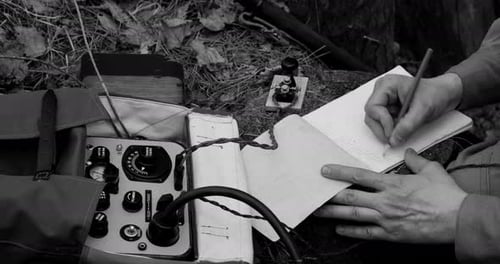 Man Writing Outdoors with Radio Communication Device