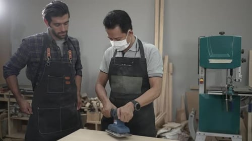 Carpenters are working together at workshop.