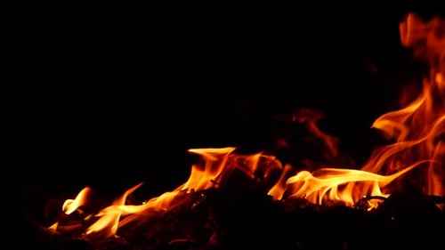 Fire burning red flame effect behind substance low on ground in the dark