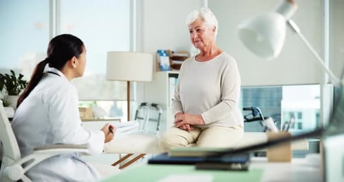 Doctor Consulting with a Senior Woman at Clinic