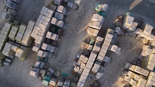 Luftbild eines Industriehofs mit gestapelten Baumaterialien