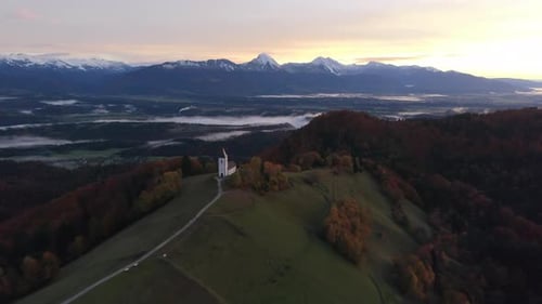 Spectacular aerial view of the Church of Saints Primus and Felician in Jamnik during sunrise