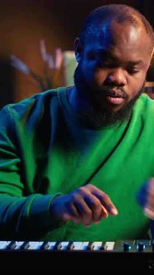 Adult Playing Keyboard in Dimly Lit Studio
