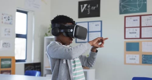 African youth male wearing VR headset standing in classroom, simulation starting, testing controls