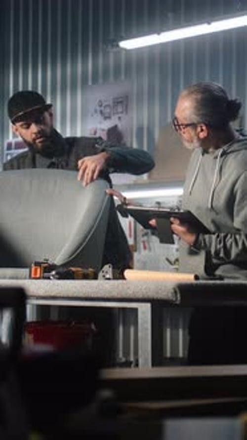 Mature Carpenter or Designer Uses Tablet Computer Consults with Male Colleague