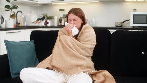 Woman Feeling Sick, Covered in Blanket on Couch