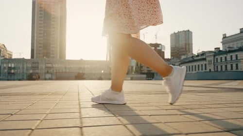 Accelerated Steps of a Girl Walking Down the Street in the City