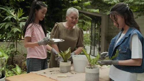 Family Planting Potted Plants Together in Garden