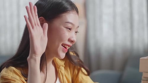 Close Up Of Young Asian Female Raising Her Hand To Ask Question While Studying On A Laptop At Home