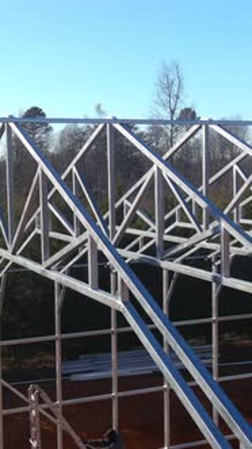 Construction of a Metal Framework for a Large Industrial Building on a Clear Sunny Day in a Rural
