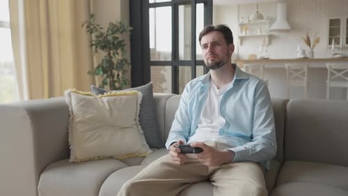 Man Winning Video Game at Home on Couch
